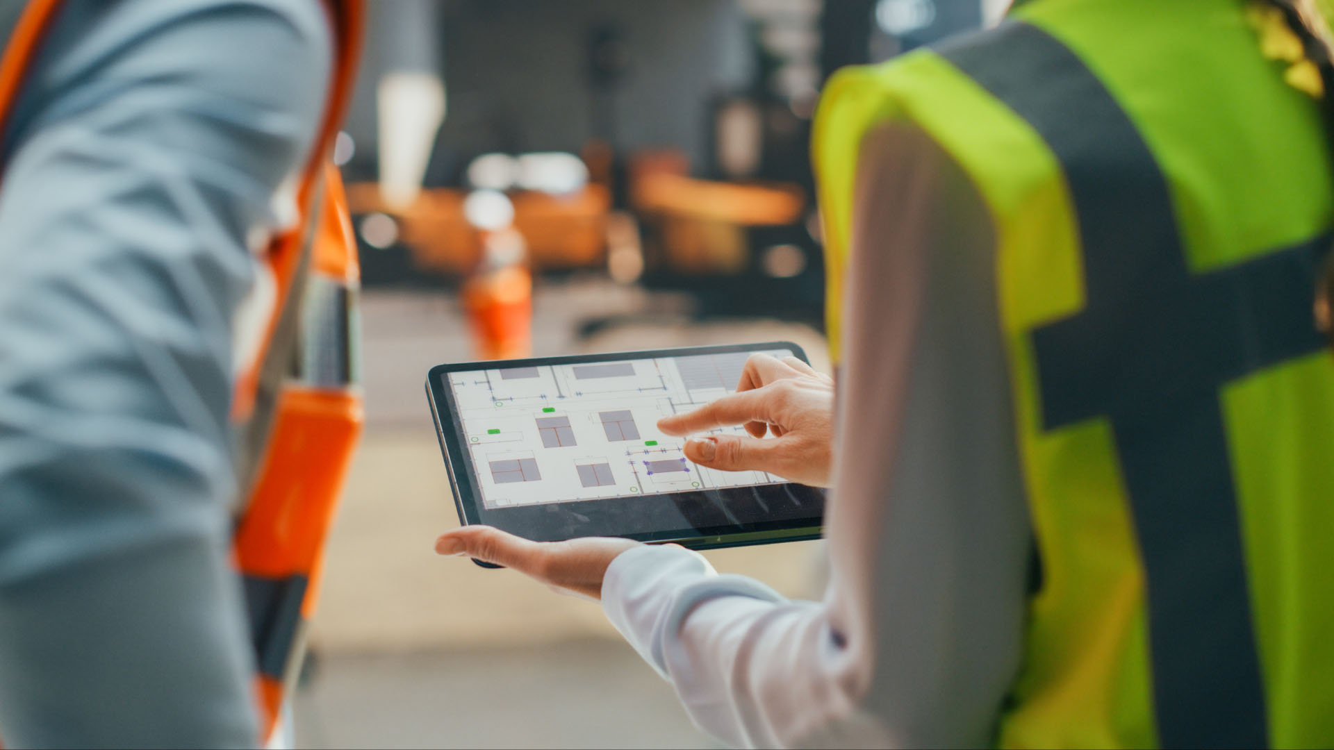 To lagermedarbejdere kigger på en tablet for at se deres WMS system