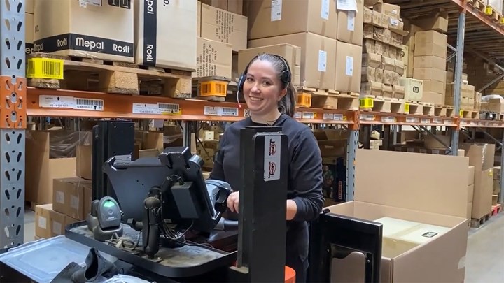 An F&H employee utilizes a headset to integrate LOGIA WMS with pick-by-voice for efficient warehouse picking.