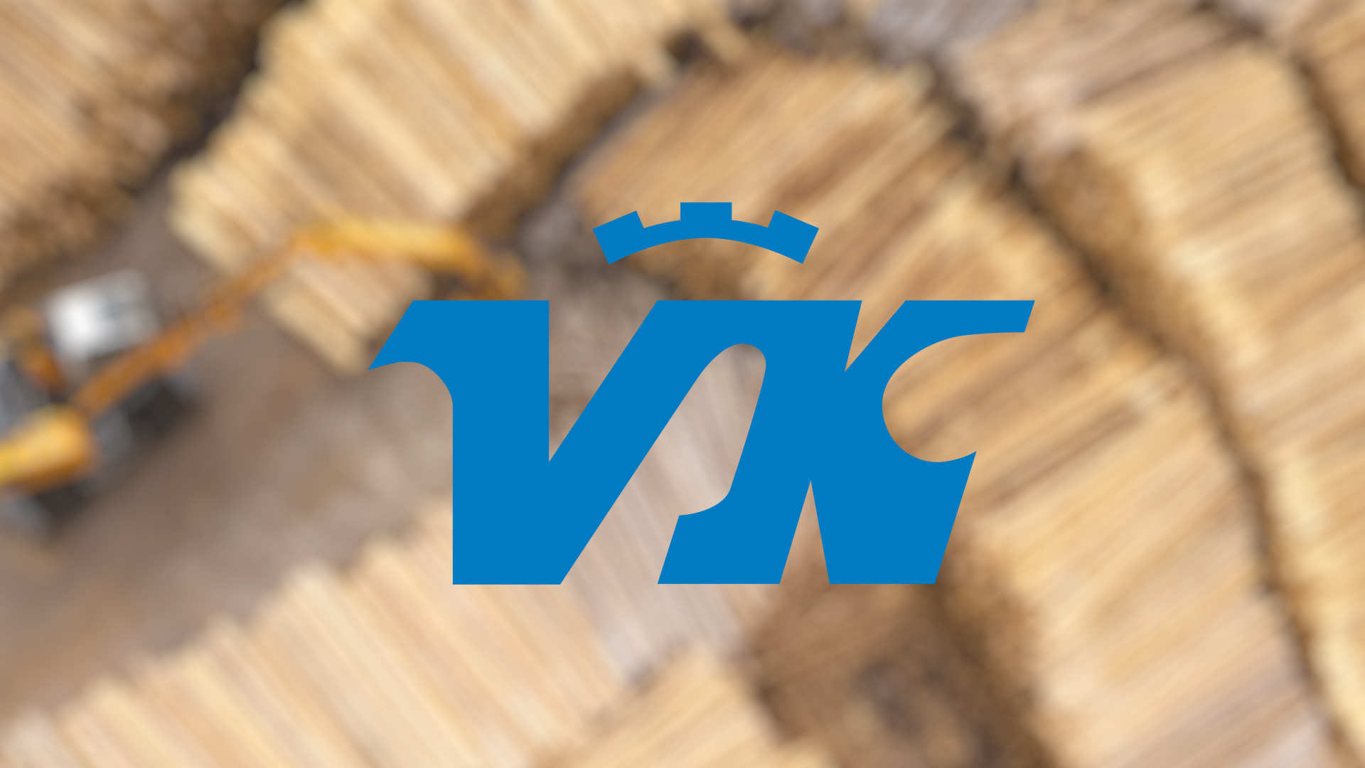 Blurred image of stacked logs with a yellow excavator in motion. A blue logo with a crown-like element overlays the scene.
