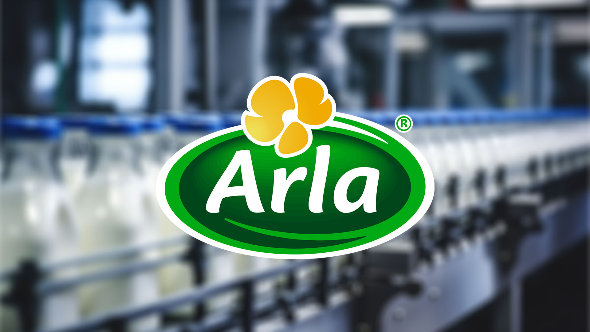 A blurred image with milk bottling line in a factory background with the Arla logo in the foreground. 
