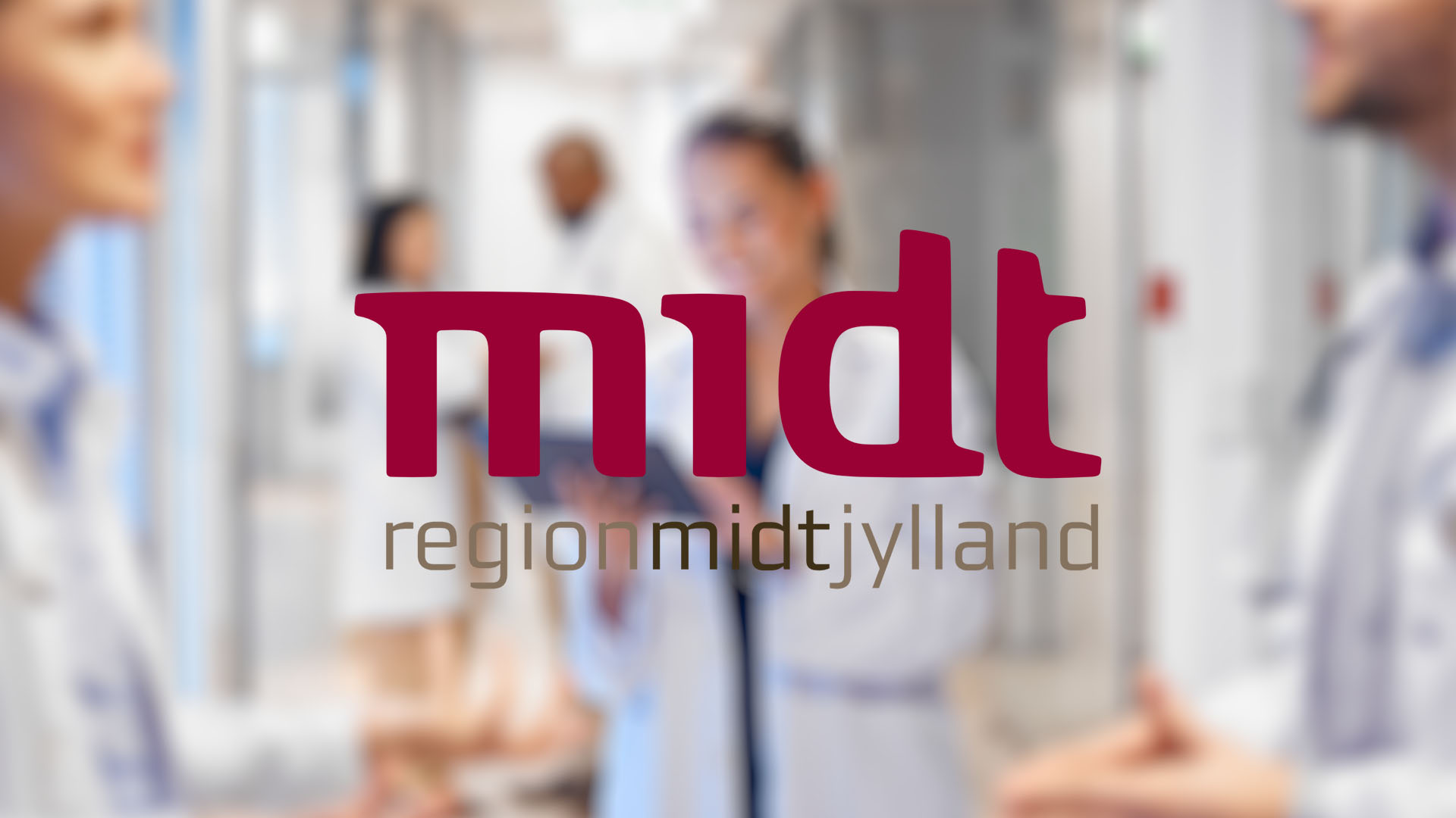 Blurry image of medical professionals in white coats in a hospital corridor. Centered text reads "midt region midtjylland" in bold red and gray letters.
