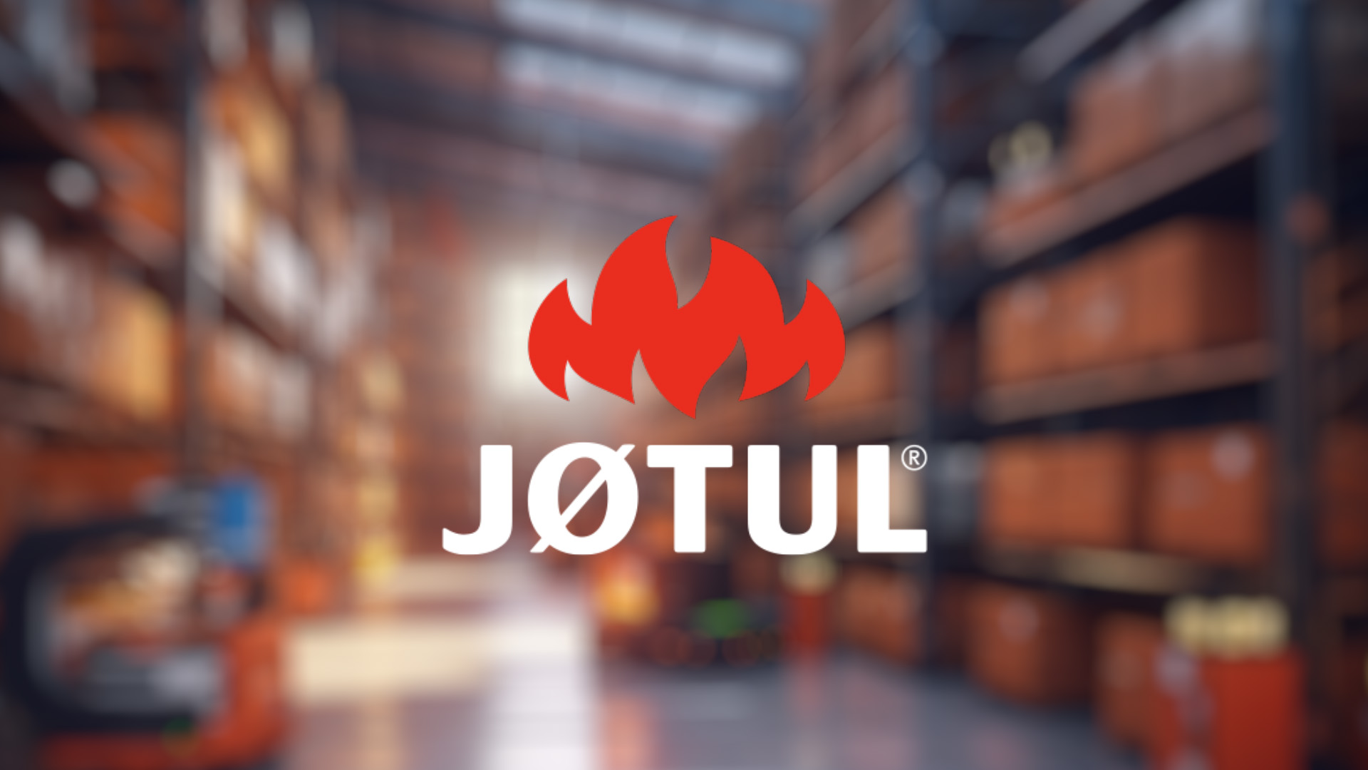 Red flame logo above "JØTUL" text on a blurred warehouse background with stacked boxes on shelves, creating a warm and industrious atmosphere.