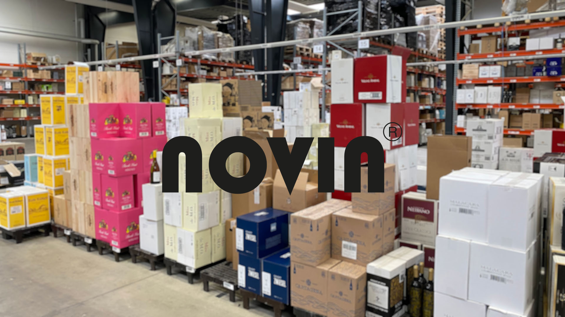 Warehouse filled with stacked boxes of various colors, including red, yellow, and pink. The logo for "novin" is prominently displayed over the image.