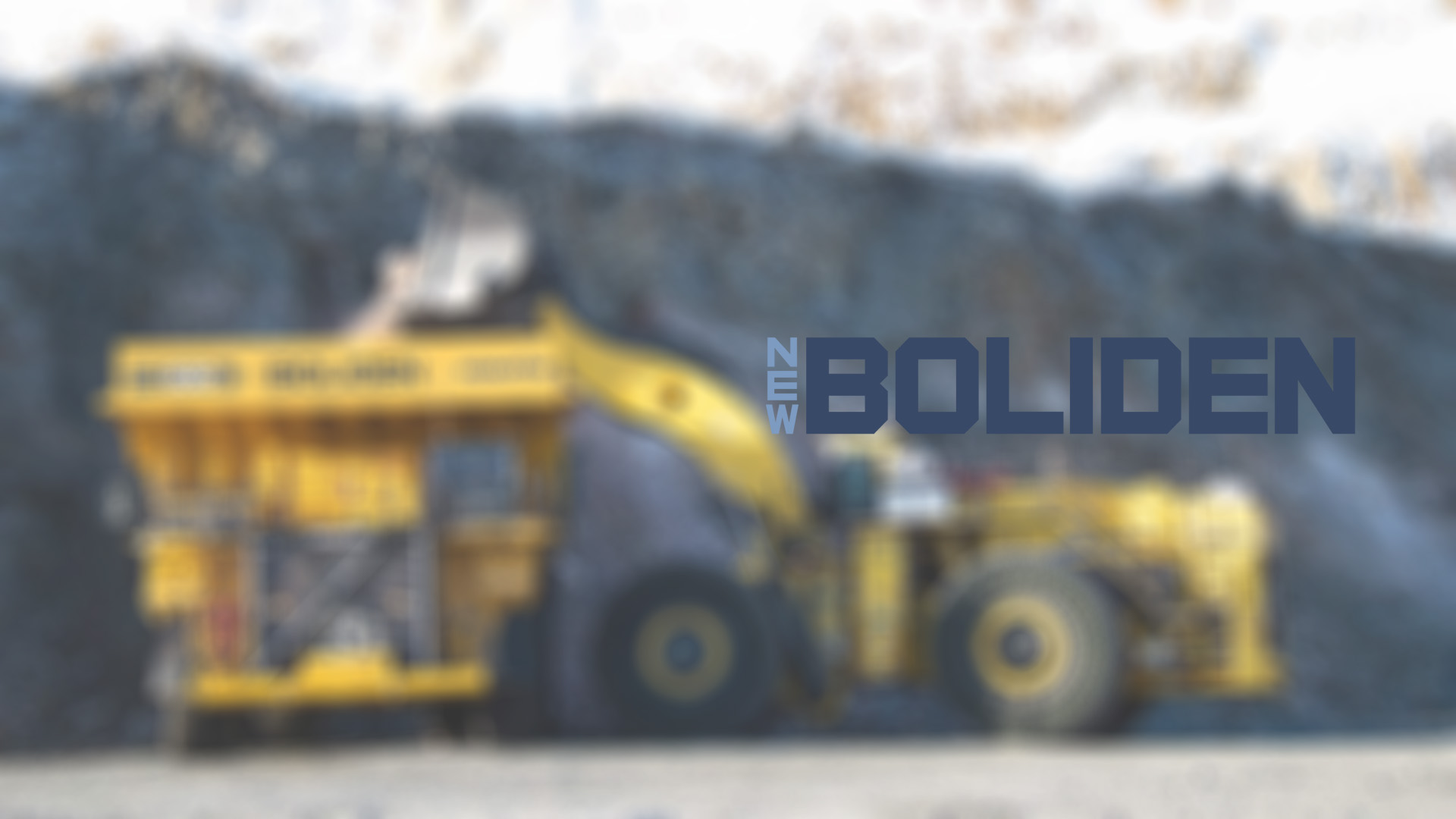Yellow mining dump truck and excavator at a rocky excavation site.	 Boliden logo is in the foreground.